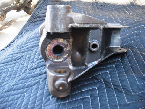 1986 Ford Bronco - A close-up view of a welded metal part, possibly a suspension component, resting on a blue quilted mat. The registry claims it is from a 19…