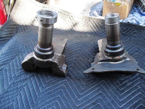 1986 Ford Bronco - Pair of front wheel spindles, likely for a 4x4 vehicle, resting on a protective mat.
