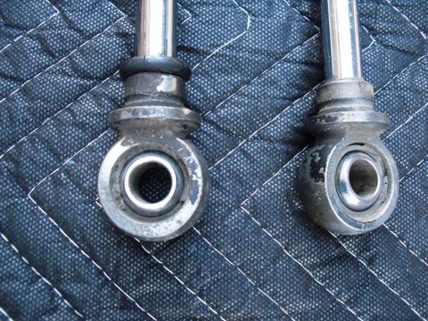 1986 Ford Bronco - Close-up of two shock absorber rod ends with visible bushings and metal components.