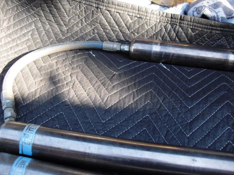 1986 Ford Bronco - Close-up of Bilstein shock absorbers with blue branding bands visible.
