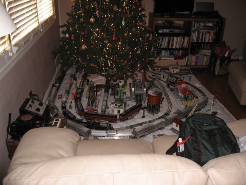 1994 Ford Bronco - A detailed model train layout is set up around a decorated Christmas tree, complete with various train cars and structures.