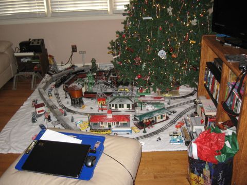 1994 Ford Bronco - A detailed model train set is arranged around a Christmas tree on the floor.