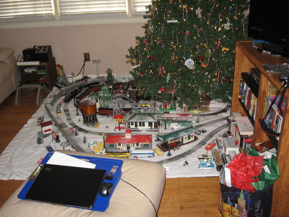 Model train set with buildings, trees, and a Christmas tree