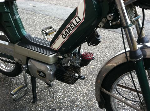 1981 Garelli Rally Sport - A green moped with 'GARELLI' branding is shown from the side, chrome accents and pedals.