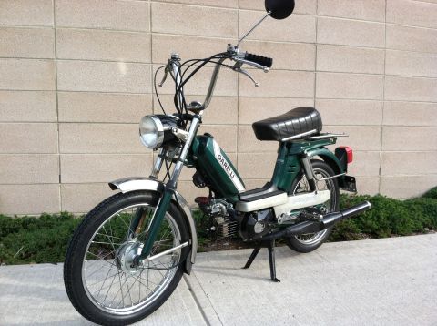 1981 Garelli Rally Sport - This green moped features chrome accents and a classic design, parked against a brick wall.