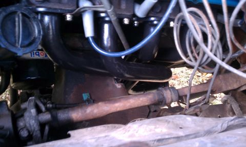 1979 Ford Bronco - Close-up of engine components in a 1979 Ford Bronco, including the exhaust manifold and oil filter.