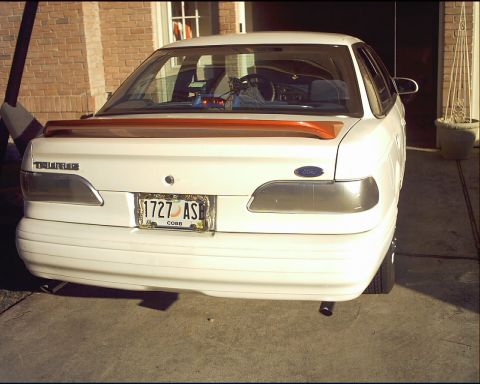 1994 Ford Taurus - Rear view of a white 1994 Ford Taurus sedan parked in a driveway.