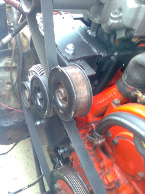 1984 Ford Bronco - Close-up view of the engine bay, focusing on the serpentine belt system and various pulleys.