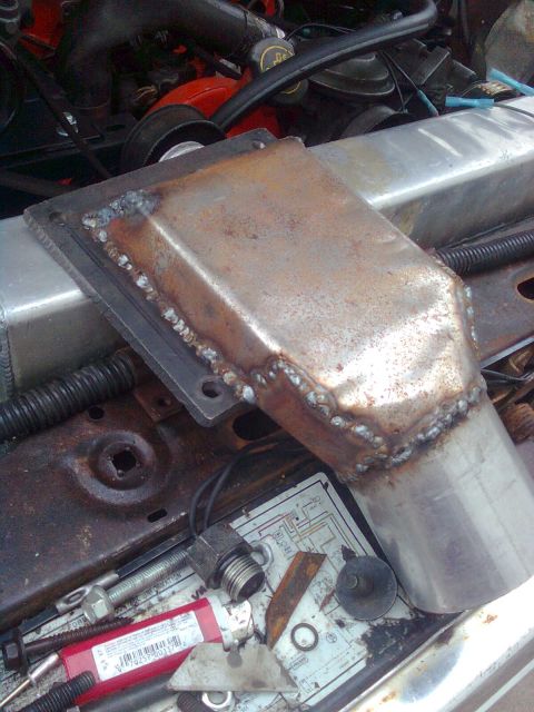 1984 Ford Bronco - A custom-fabricated metal intake pipe is shown installed in the engine bay, with welding visible on the pipe's seams.