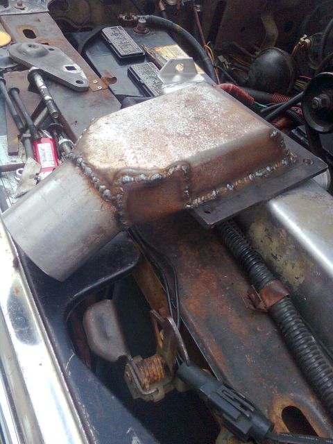 1984 Ford Bronco - Custom exhaust component installed in the engine bay of a vehicle.