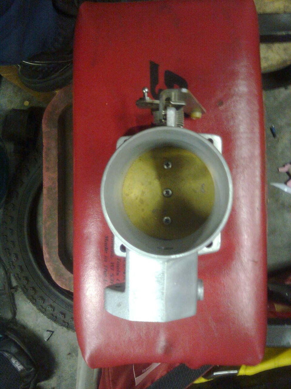 Throttle body part on red surface