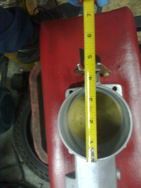 1984 Ford Bronco - Measuring a throttle body with a tape measure. Supermotors.net logo is visible.