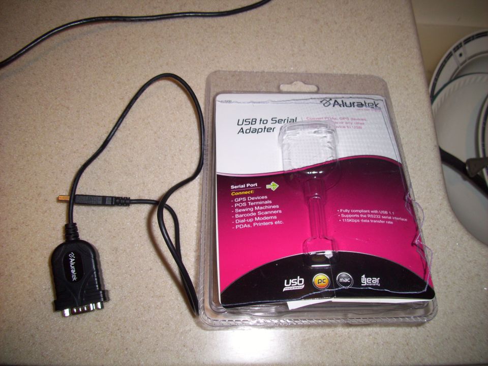 USB to Serial Adapter in packaging next to its cable