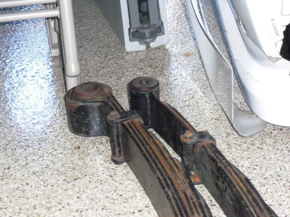 Leaf springs and shackles on a speckled floor