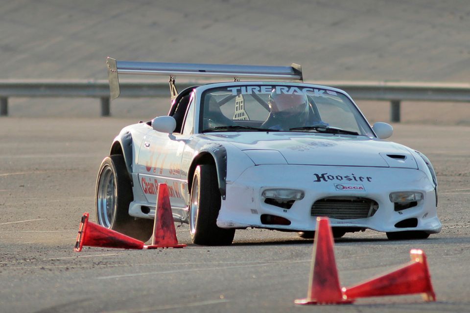 White 1991 Mazda Miata with Hoosier tires and a large rear spoiler on a track