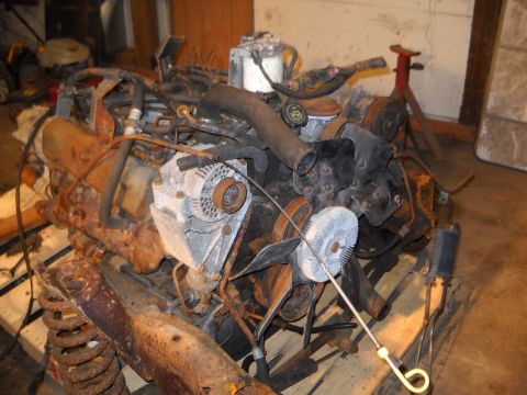 1988 Ford F-250 - A disassembled engine sits on a wooden pallet, showing signs of rust and wear.