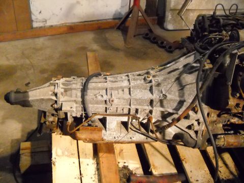 1988 Ford F-250 - Transmission assembly, likely for a truck, resting on wooden pallets in a workshop setting.