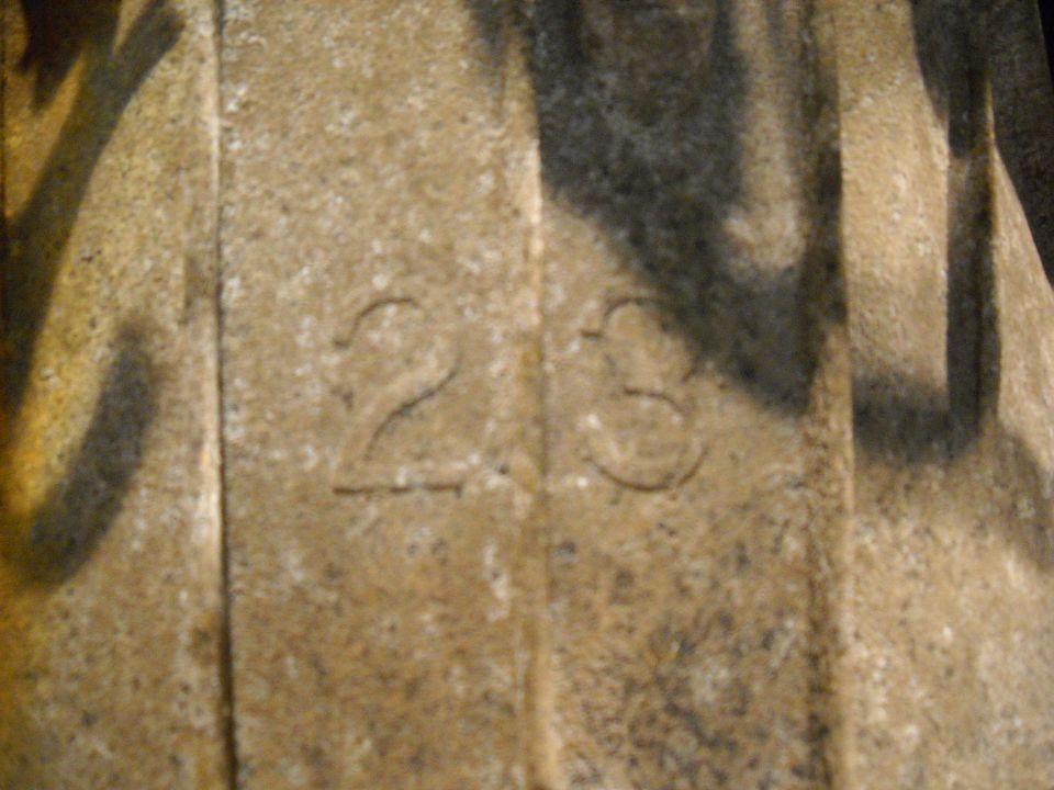 Engine part with embossed numbers 23. The part is tan and textured