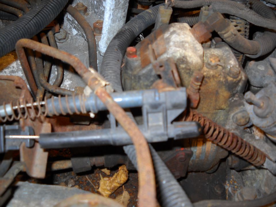 Close-up of rusty engine parts, cables, and wiring harness