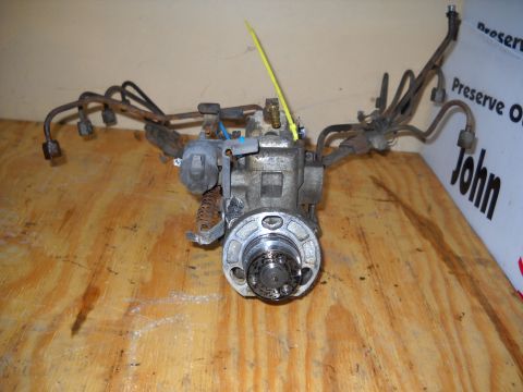 1988 Ford F-250 - A fuel injection pump, likely from a diesel engine, is shown on a wooden workbench.