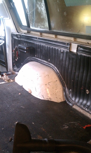 1978 Ford Bronco - Interior view showing the rear wheel well and a black padded door panel.