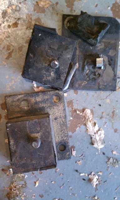 1978 Ford Bronco - These appear to be old suspension components, possibly from a vehicle, resting on a floor.