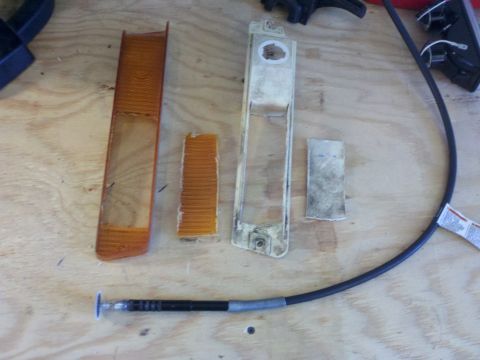 1978 Ford Bronco - Disassembled vehicle lighting components laid out on a workbench for modification or repair.