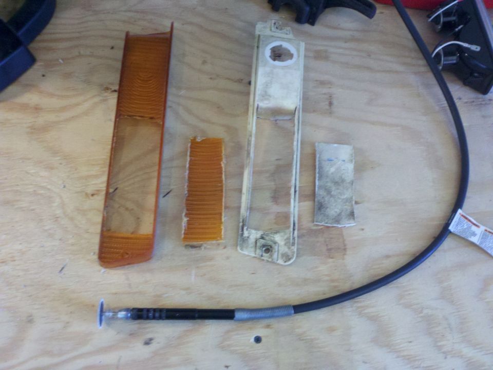 Disassembled amber and clear plastic vehicle light lenses and housings on a wooden surface