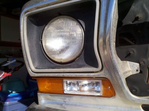 1978 Ford Bronco - Close-up of the driver's side headlight and amber turn signal assembly on a classic Ford truck or SUV. The vehicle appears to be in a garag…