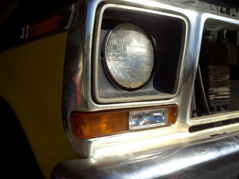 1978 Ford Bronco - This close-up shot focuses on the headlight and turn signal assembly of a vintage Ford truck.