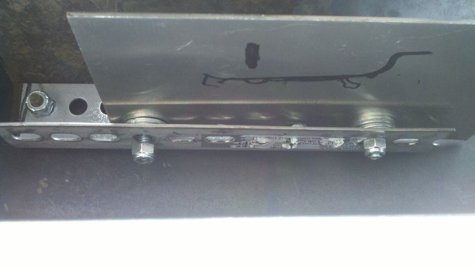 Metal bracket with visible text and fasteners, attached to an unseen surface