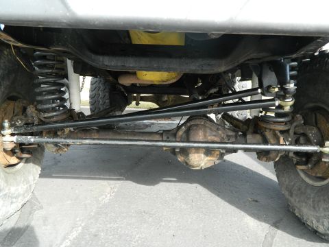 1979 Ford Bronco - Close-up of the vehicle's front axle and suspension system, focusing on the steering and suspension components.