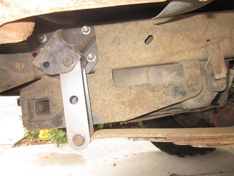 1985 Ford Bronco - Detail of a vehicle's undercarriage, showing frame rust and a suspension component.