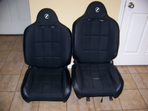 2000 Jeep TJ - A pair of black racing seats are shown indoors, with a watermark for Supermotors.net at the bottom right.