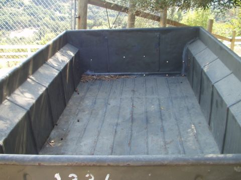 1979 Ford Bronco - View inside a truck bed, showing the floor and side panels. Debris is present on the floor.