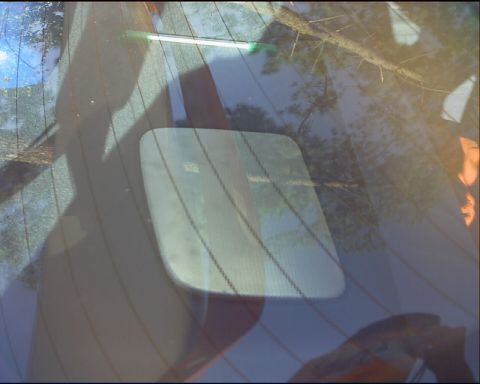 1994 Ford Taurus - Rear window of a vehicle, showing defroster lines and reflections.