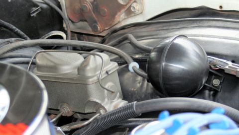 1976 Ford Ranchero - This image shows a close-up view of the engine bay, focusing on the brake fluid reservoir and a vacuum canister.