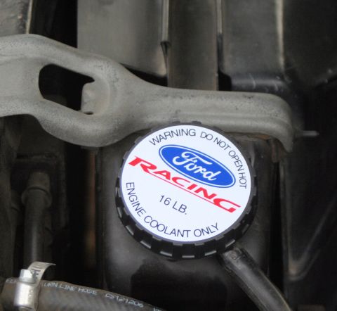 1976 Ford Ranchero - A close-up of a Ford Racing engine coolant cap, indicating a 16 LB pressure rating and a warning to not open when hot.