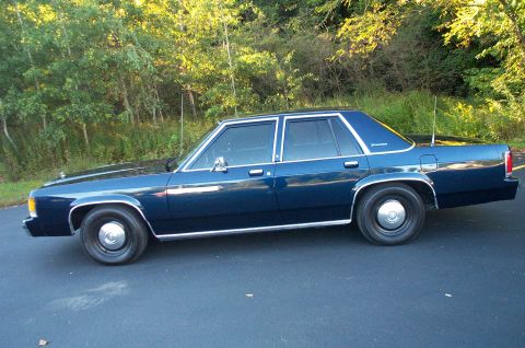 1991 Ford LTD Crown Victoria - Side profile of a 1991 Ford Crown Victoria LTD sedan with dark blue paint and chrome accents.