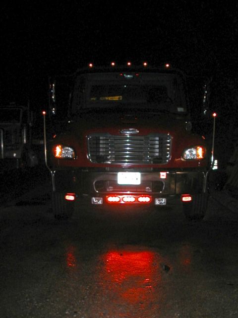 1994 Ford Bronco - A red semi-truck is parked at night, its front grille and lights clearly visible.