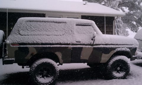 1979 Ford Bronco - A 1979 Ford Bronco with camouflage paint sits covered in snow during a winter storm.