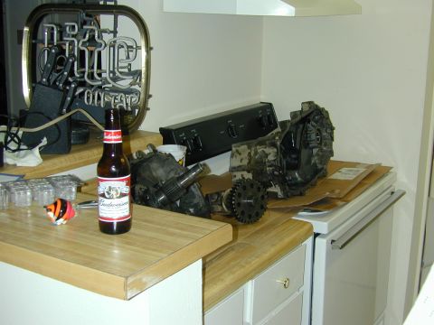 1996 Ford Bronco - Transmission parts are laid out on a kitchen counter next to a bottle of beer.