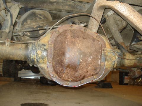 1989 Ford F-250 - Close-up of a heavily rusted rear differential assembly, showing bolts and brake lines.