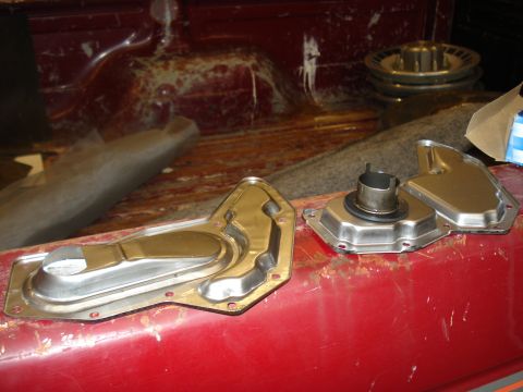 1989 Ford F-250 - Transmission filter and pan removed from a red vehicle, likely for maintenance or replacement.