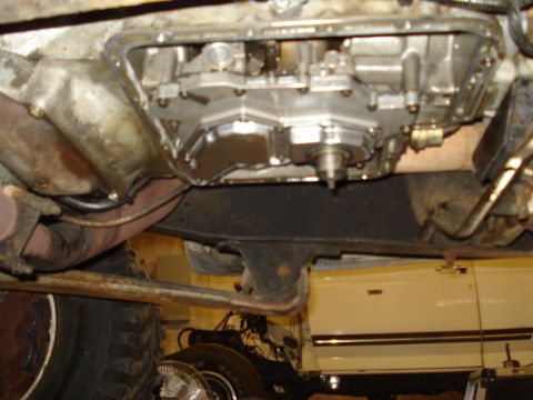 1989 Ford F-250 - Underside view of a vehicle's transmission pan and exhaust system, with another vehicle visible in the background.