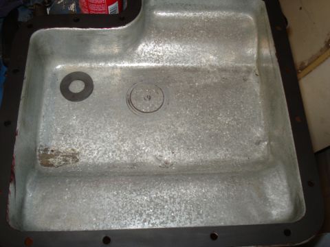 1989 Ford F-250 - This is a close-up view of a vehicle's oil pan, showing a gasket and a stamped number.