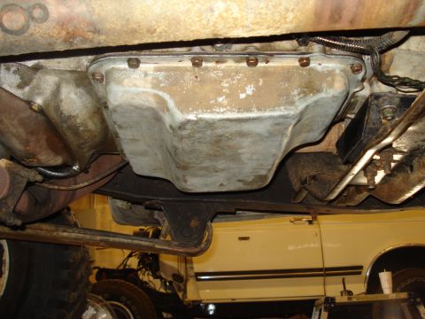 1989 Ford F-250 - Underside view of a vehicle's transmission pan, showing mechanical components and a portion of another vehicle.