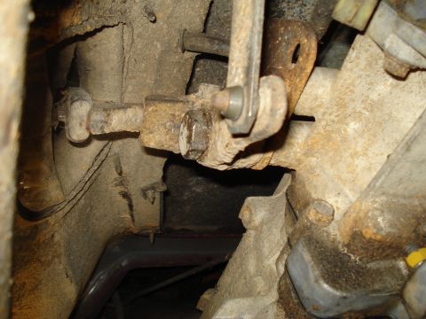 1989 Ford F-250 - Detail of a vehicle's drivetrain linkage, showing rusted metal components and a bolt.