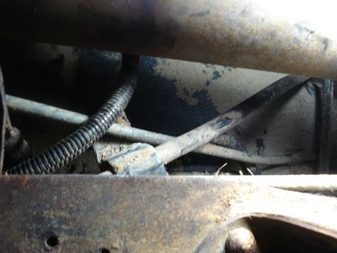 1989 Ford F-250 - Close-up of vehicle undercarriage components, including hoses and frame structure.