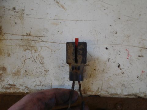 1989 Ford F-250 - Close-up of an electrical connector with a red indicator and exposed wires, held by a hand.